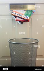 election-leaflets-coming-through-letterbox-with-a-bin-below-BBGMMP.jpg
